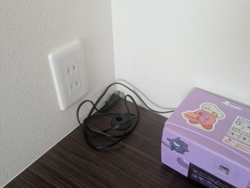 造作デスク上のコンセント位置のアップ。手元で使いやすく、充電や家電の使用に便利な配置になっている。