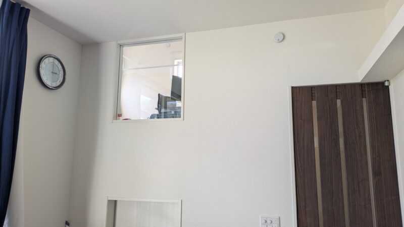 リビングから見上げた1.5階書斎の窓と立体的な空間構成