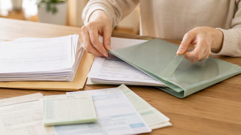 住宅ローン審査に向けて書類をファイルに整理している手元